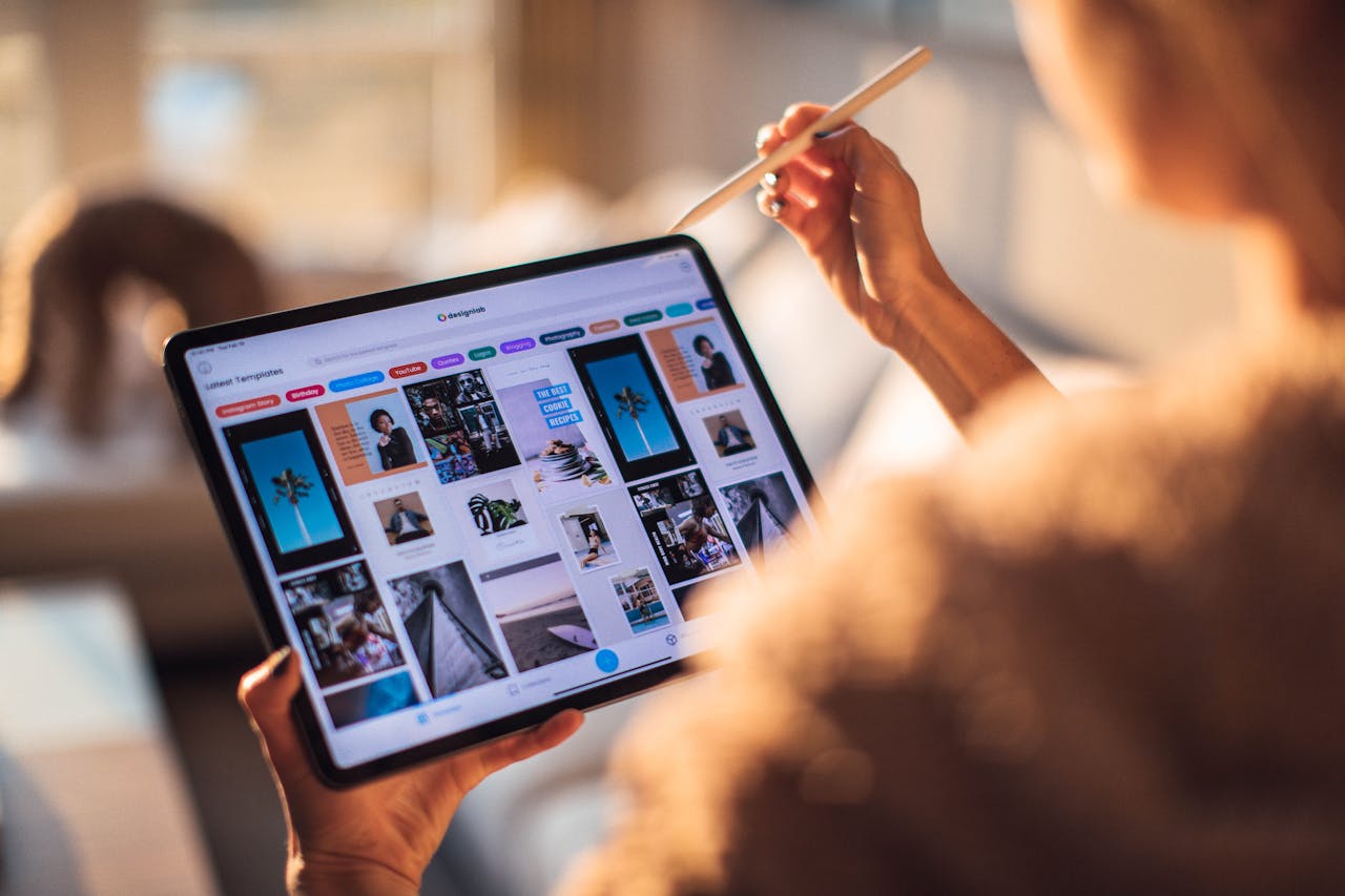 my-steps A person uses a digital tablet with a stylus indoors in a warm, cozy setting.